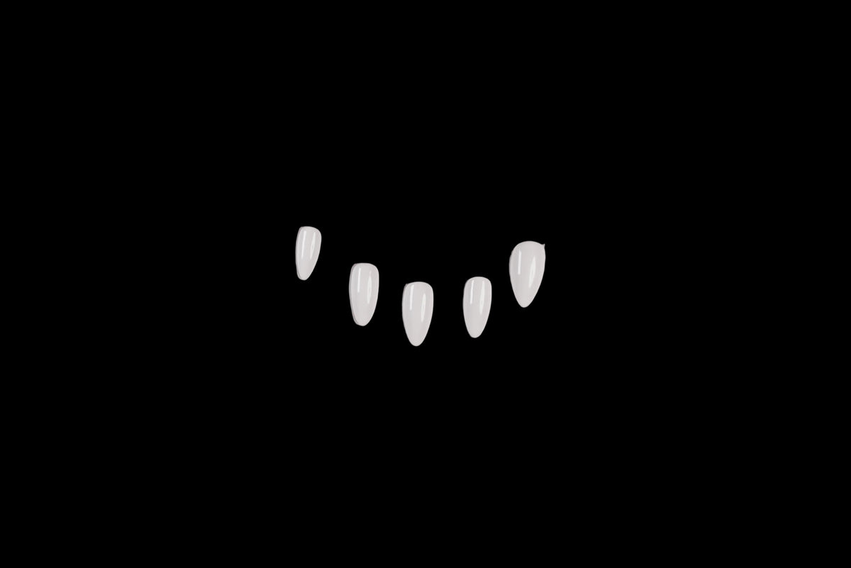 Five clear, teardrop-shaped press-on nails arranged in a gentle arc on a plain, white background.